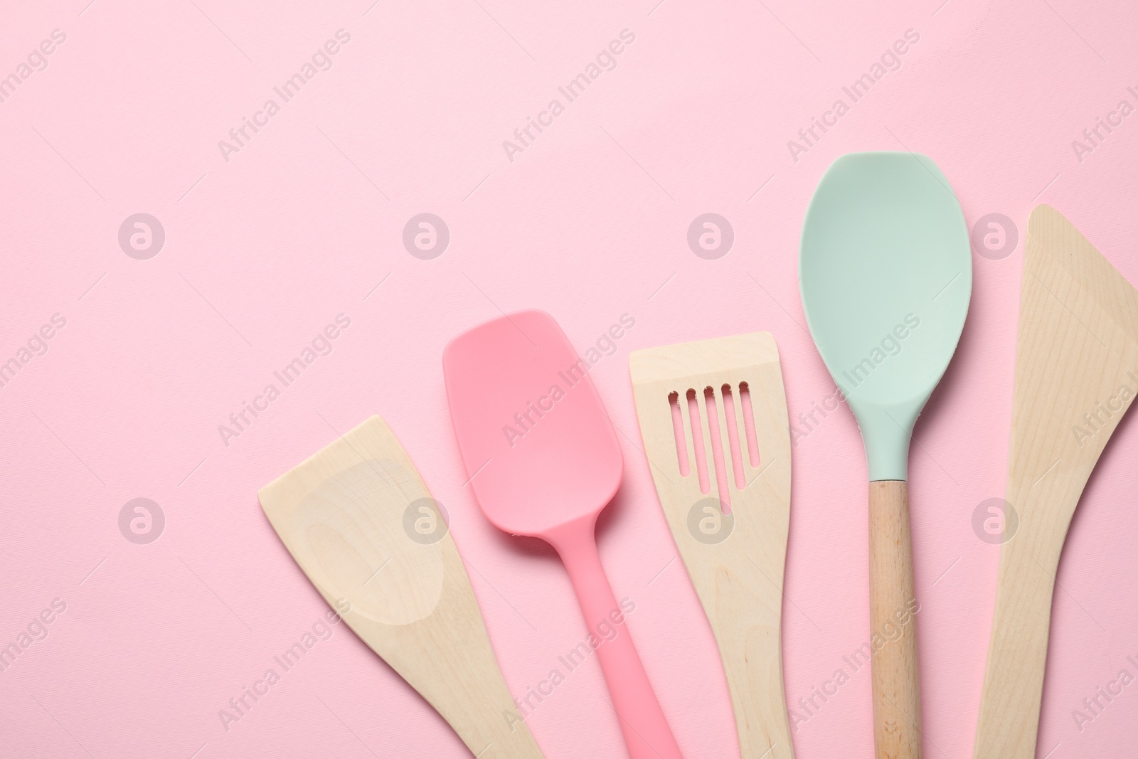 Photo of Different spatulas on pink background, flat lay. Space for text