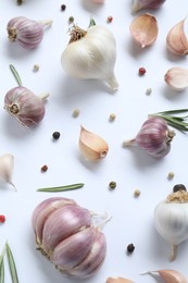 Photo of Fresh garlic, rosemary and peppercorns on white background, flat lay