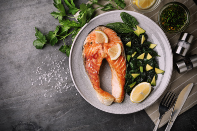 Image of Tasty salmon with spinach served on grey table, flat lay. Food photography  
