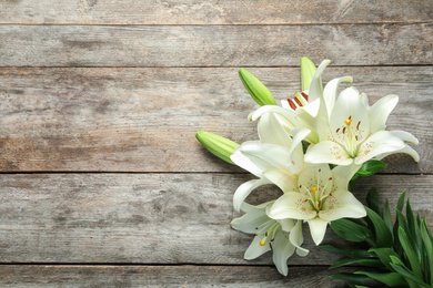 Photo of Flat lay composition with beautiful blooming lily flowers on wooden background