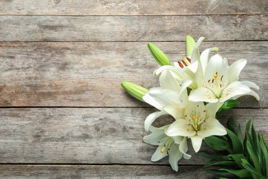 Flat lay composition with beautiful blooming lily flowers on wooden background