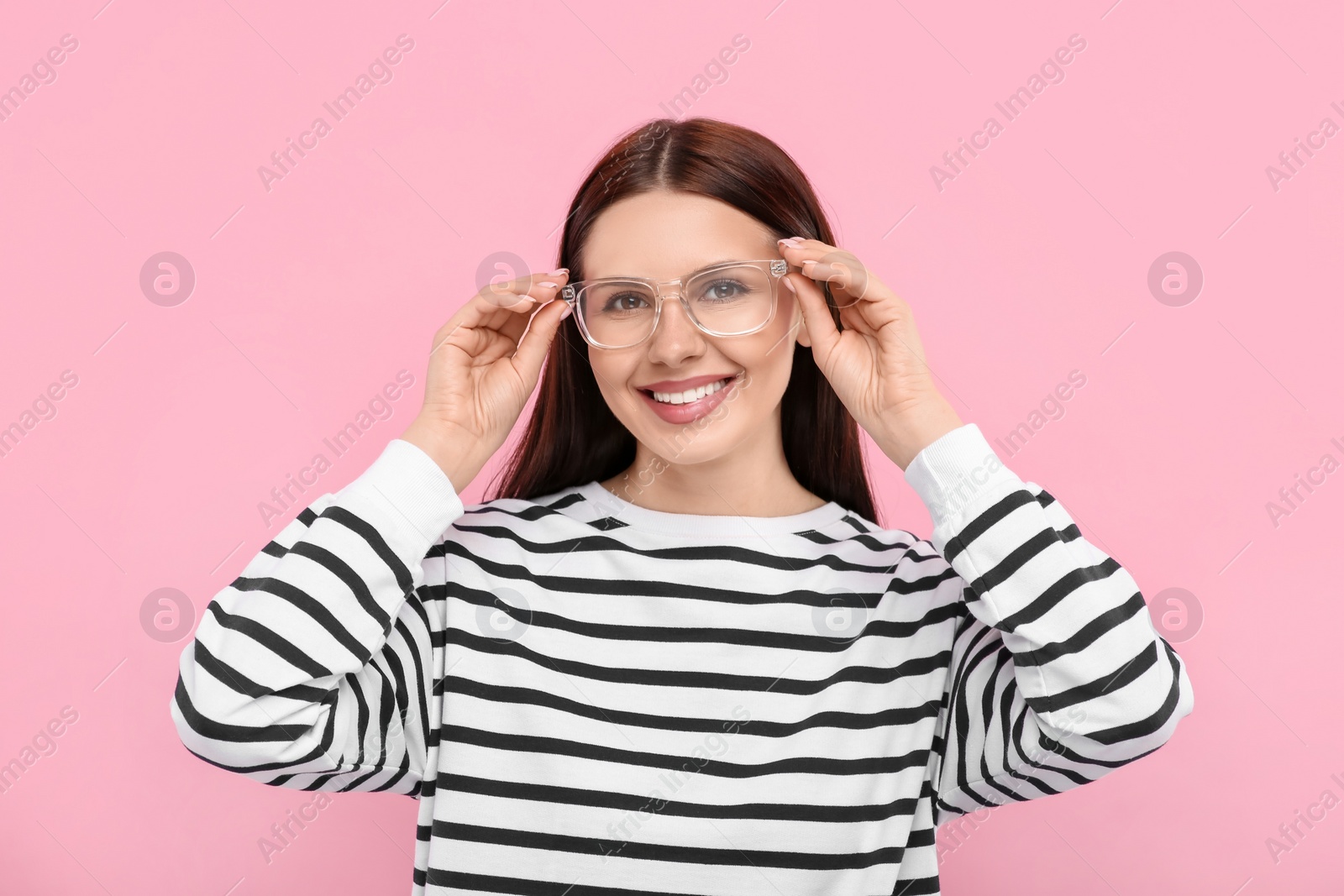 Photo of Portrait of smiling woman in stylish eyeglasses on pink background