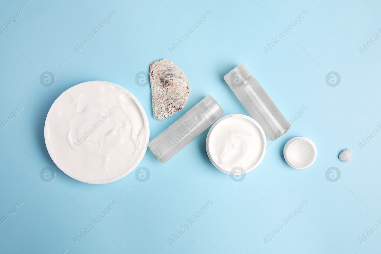 Photo of Flat lay composition with different cosmetic products on light blue background