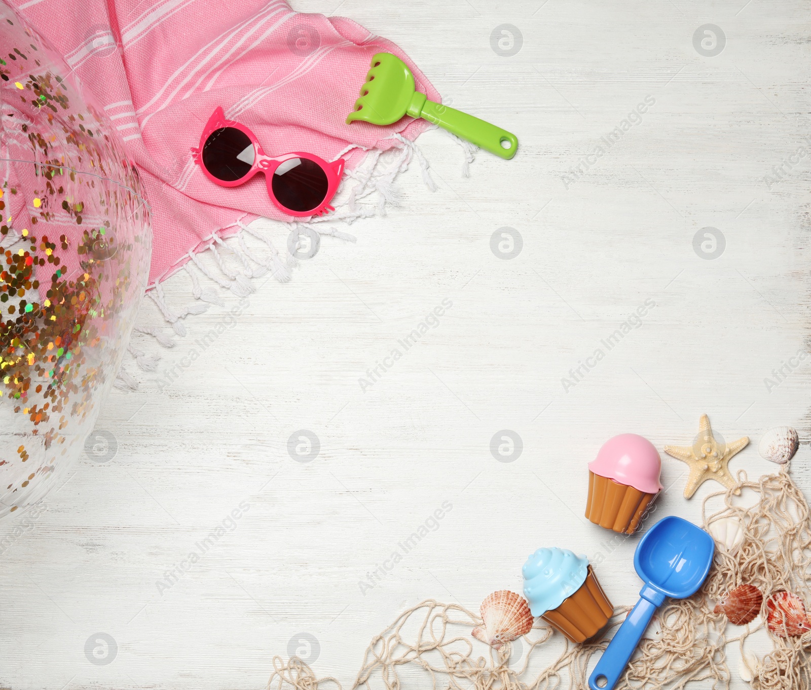 Photo of Flat lay composition with beach toys on white wooden background. Space for text