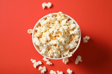 Cup with fresh tasty popcorn on color background, top view. Cinema snack