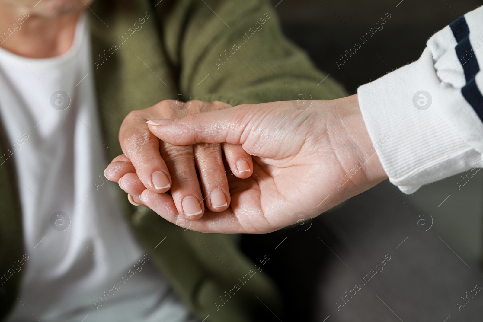 Photo of Caregiver helping elderly woman at home, closeup