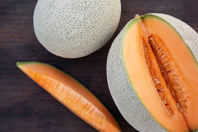 Photo of Whole and cut delicious ripe melons on wooden, flat lay