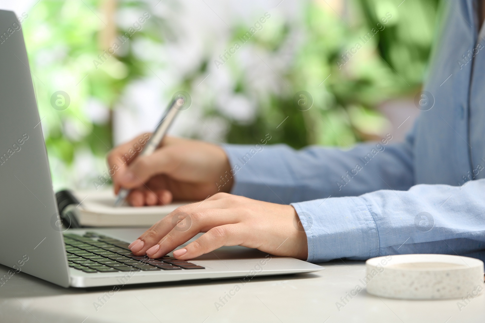 Photo of Journalist working with laptop at table, closeup