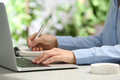 Photo of Journalist working with laptop at table, closeup