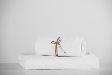 Rolled and folded soft towels on white table