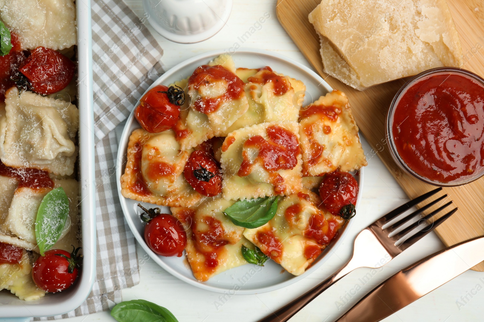 Photo of Tasty ravioli with tomato sauce served on white table, flat lay