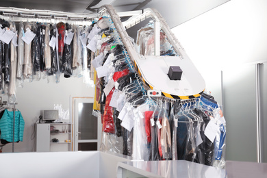Modern dry-cleaner's interior with counter and garment conveyor