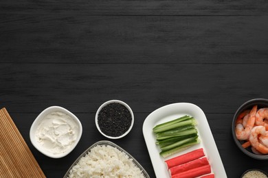 Photo of Making sushi rolls. Flat lay composition with ingredients on black wooden table. Space for text