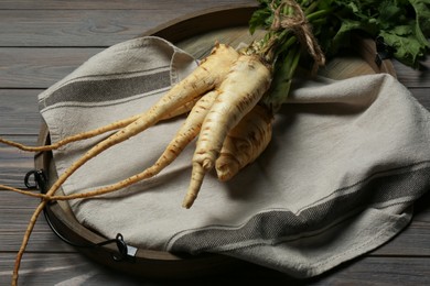 Photo of Tasty fresh ripe parsnips on grey wooden table, closeup