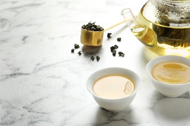 Cups of Tie Guan Yin oolong tea on marble table. Space for text