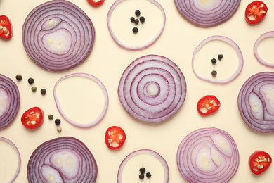 Flat lay composition with cut onion and spices on beige background