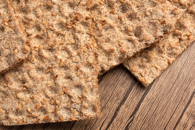 Fresh crunchy crispbreads on wooden table, closeup