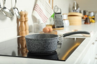 Photo of Saucepan on electric stove in kitchen. Cooking utensil