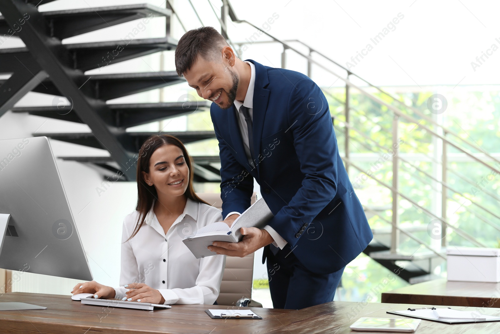 Photo of Man helping his colleague with work in office