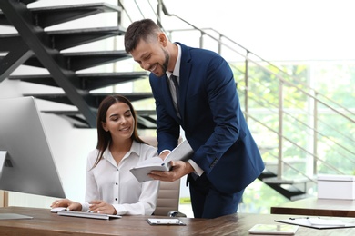 Man helping his colleague with work in office