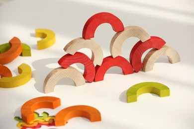 Photo of Colorful wooden pieces of play set on white table. Educational toy for motor skills development