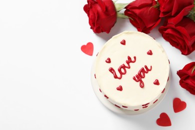 Photo of Bento cake with text Love You, paper hearts, roses and space for text on white table, flat lay. St. Valentine's day surprise