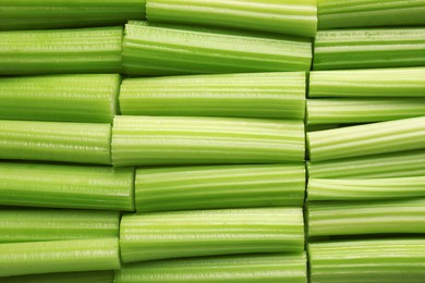 Photo of Fresh green cut celery as background, top view