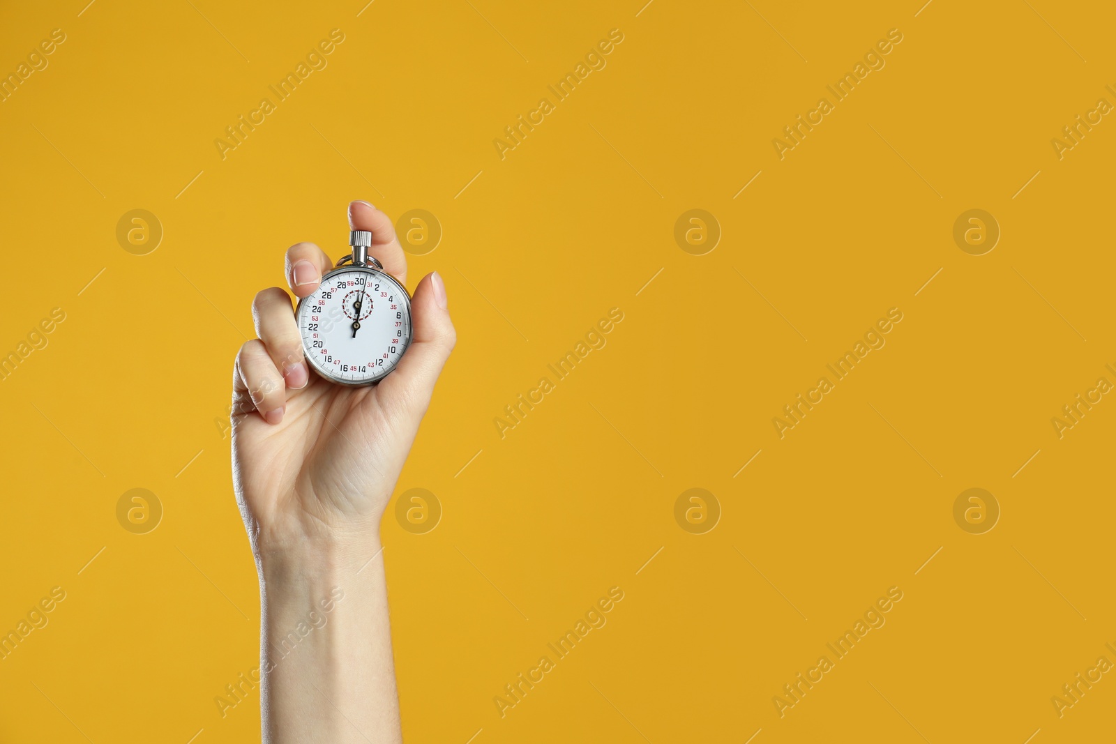 Photo of Woman holding vintage timer on yellow background, closeup. Space for text