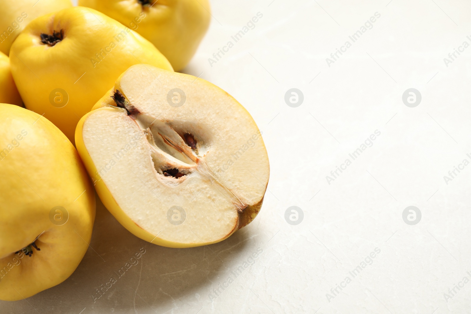 Photo of Fresh ripe organic quinces on light table, closeup. Space for text