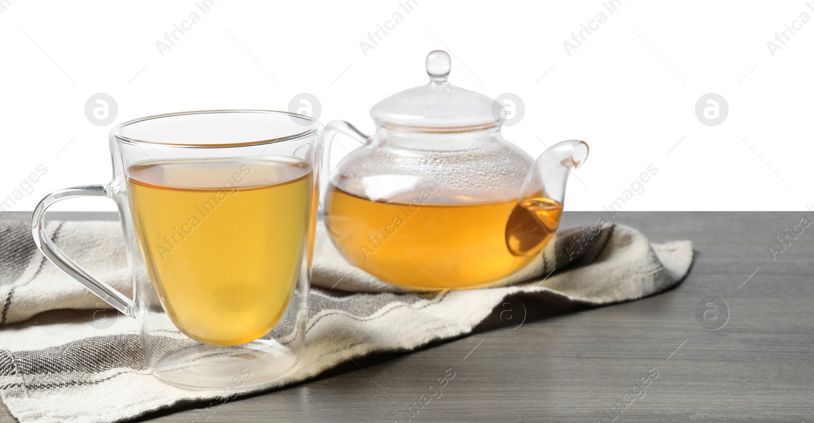 Photo of Refreshing green tea in cup and teapot on grey wooden table against white background