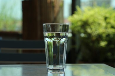 Glass of fresh water on table indoors