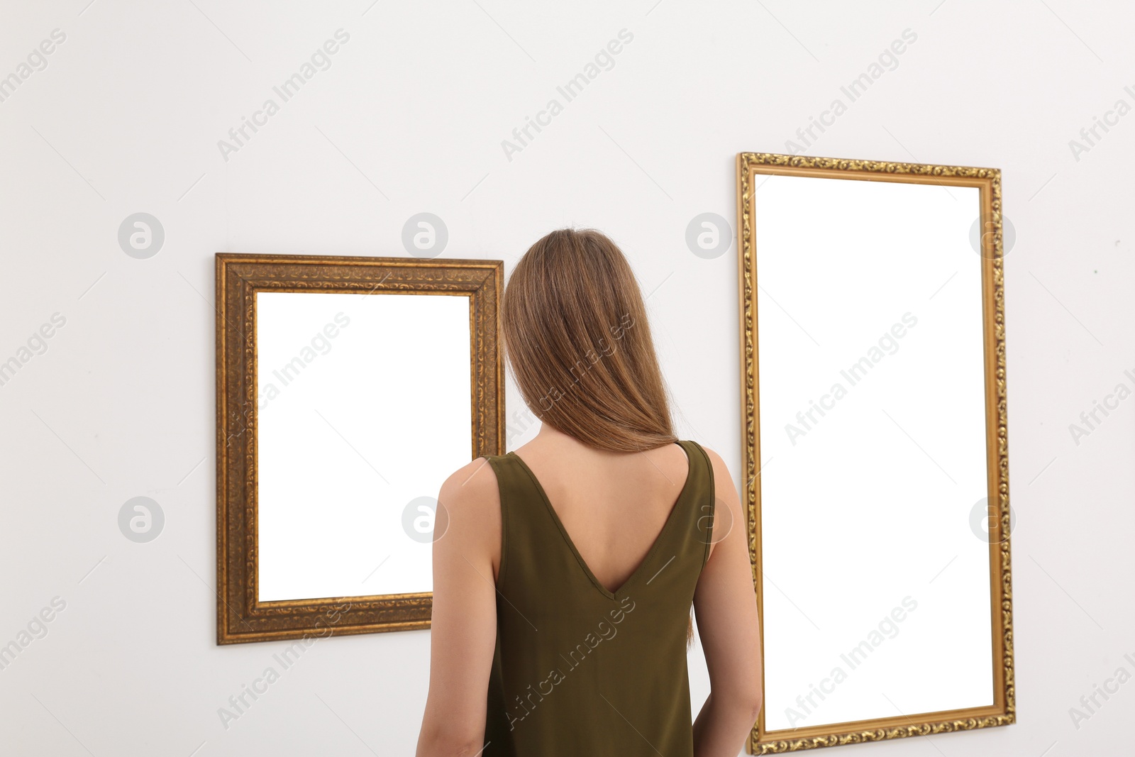 Photo of Young woman viewing exposition in modern art gallery