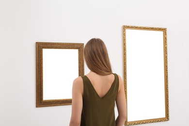 Photo of Young woman viewing exposition in modern art gallery