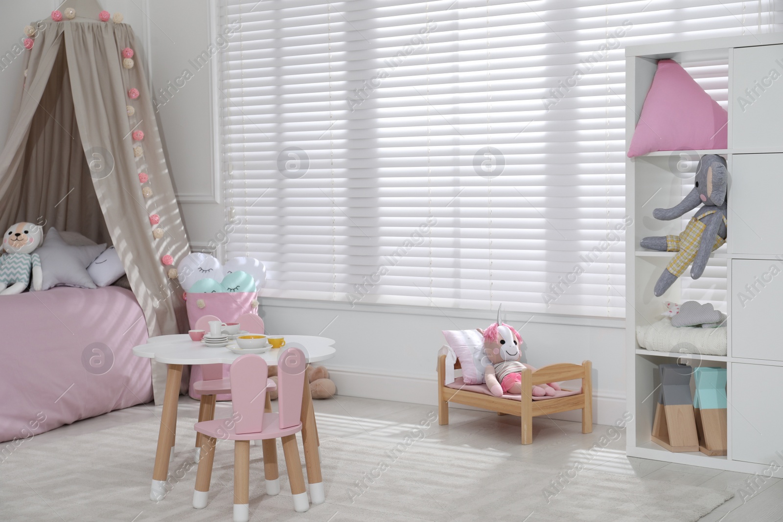 Photo of Cute child's room interior with toys and modern furniture