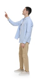 Young man pointing at something on white background