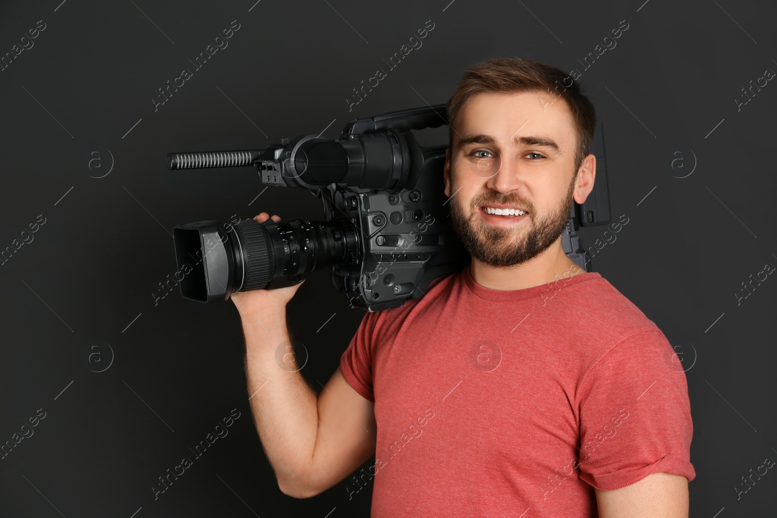 Photo of Operator with professional video camera on black background