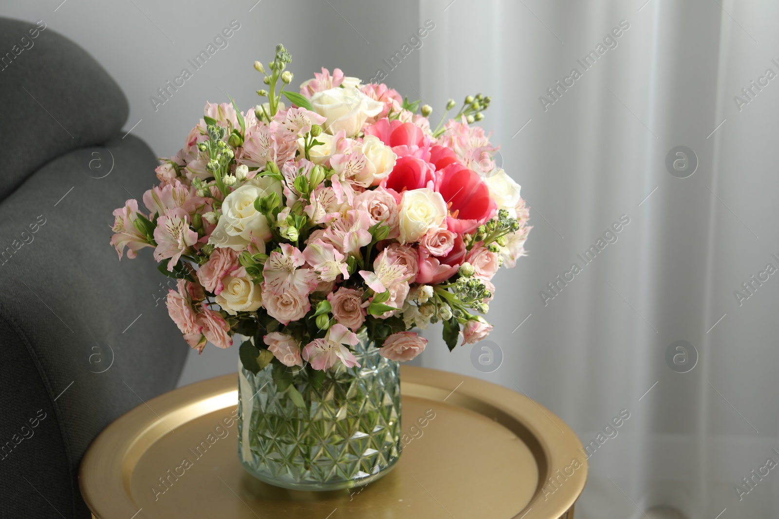 Photo of Beautiful bouquet of fresh flowers on coffee table in room, space for text