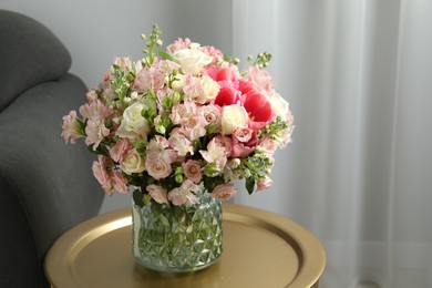Photo of Beautiful bouquet of fresh flowers on coffee table in room, space for text