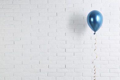 Photo of Bright balloon near brick wall, space for text. Party time