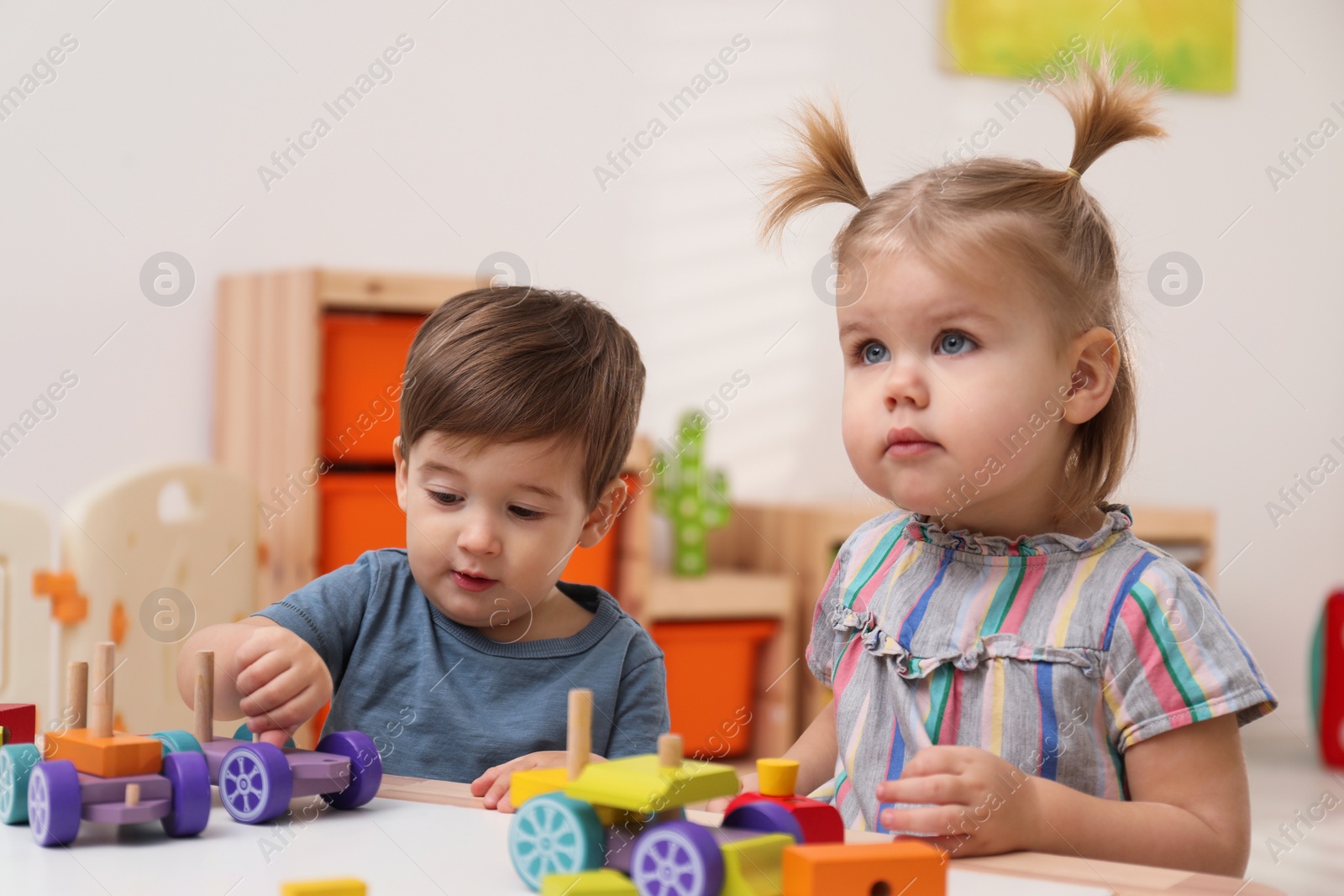 Photo of Little children playing with construction set at table