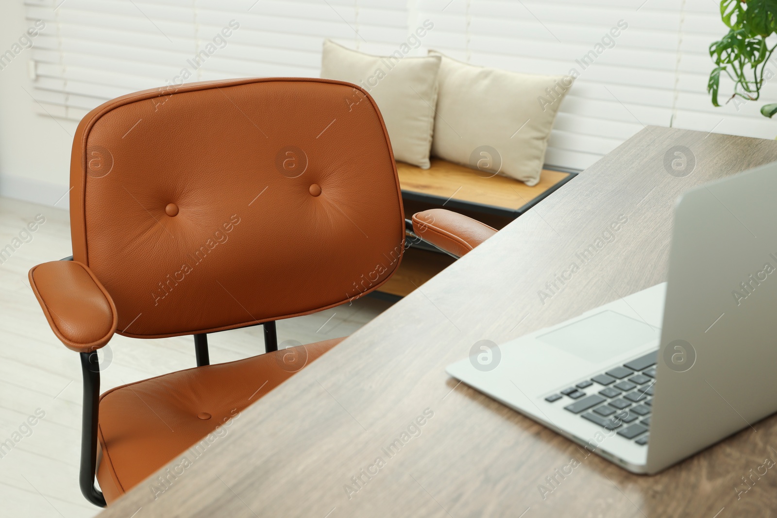 Photo of Comfortable office chair near desk at workplace