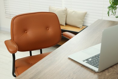 Comfortable office chair near desk at workplace