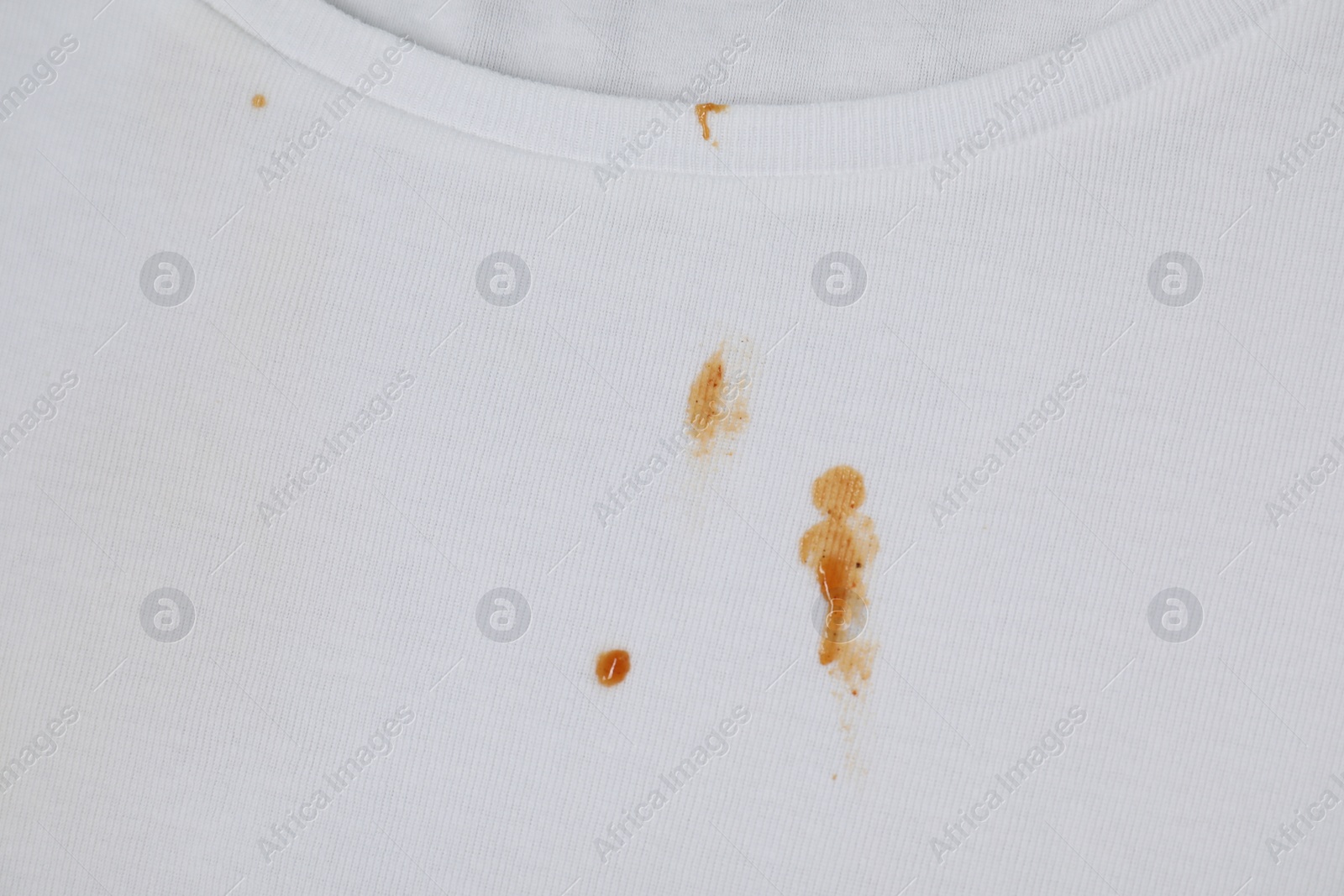 Photo of Stains of sauce on white t-shirt, top view
