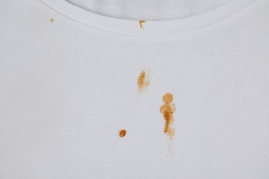 Photo of Stains of sauce on white t-shirt, top view