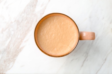 Cup of aromatic hot coffee on light background, top view