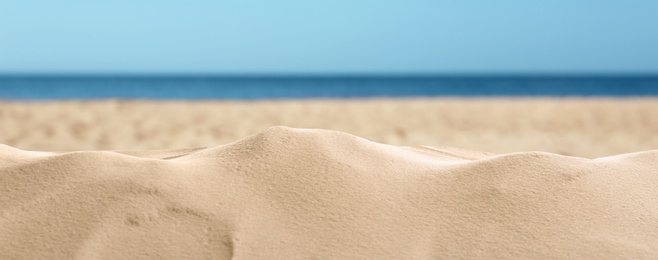 Beautiful beach with golden sand near sea, closeup view. Banner design