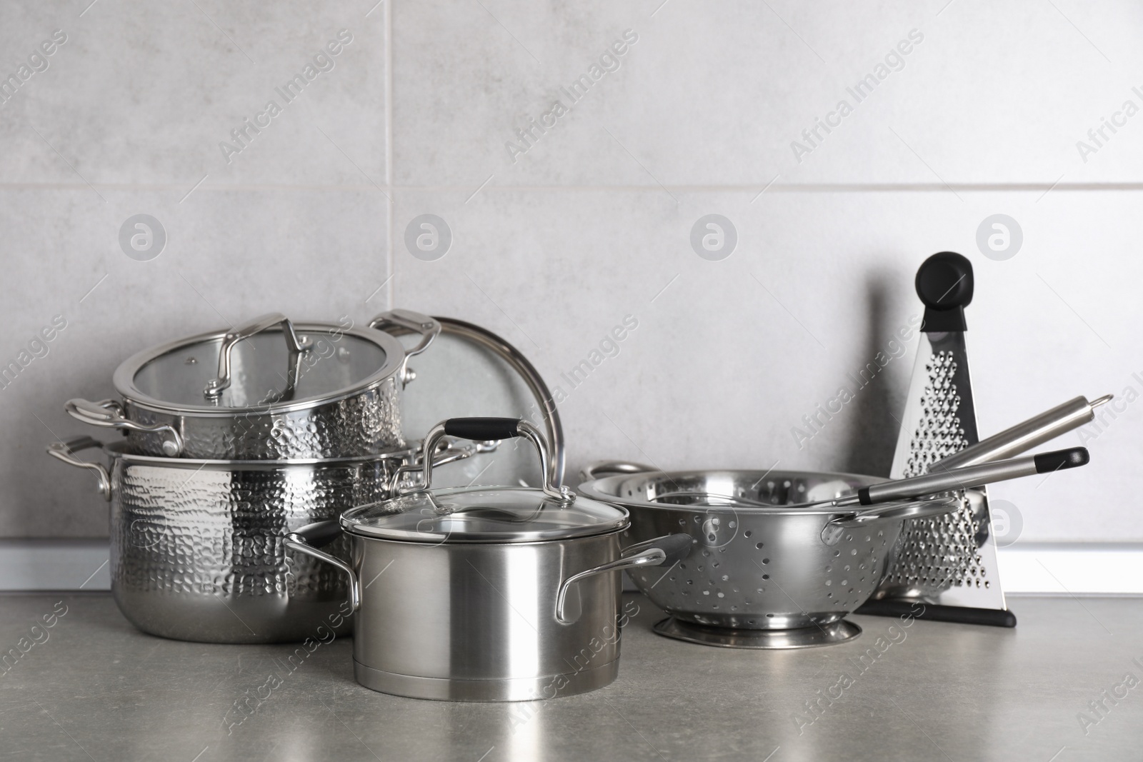 Photo of Set of different cooking utensils on grey countertop in kitchen