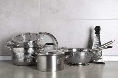 Set of different cooking utensils on grey countertop in kitchen