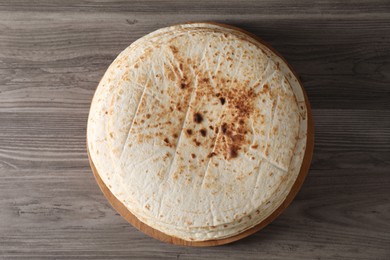 Photo of Many tasty homemade tortillas on wooden table, top view