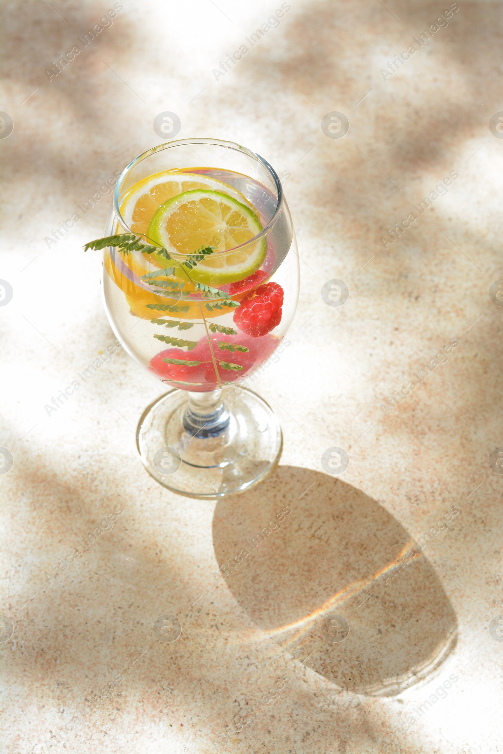 Photo of Delicious refreshing lemonade with raspberries on beige table